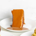 Dessert with a caramel-like topping on a white plate against a white background