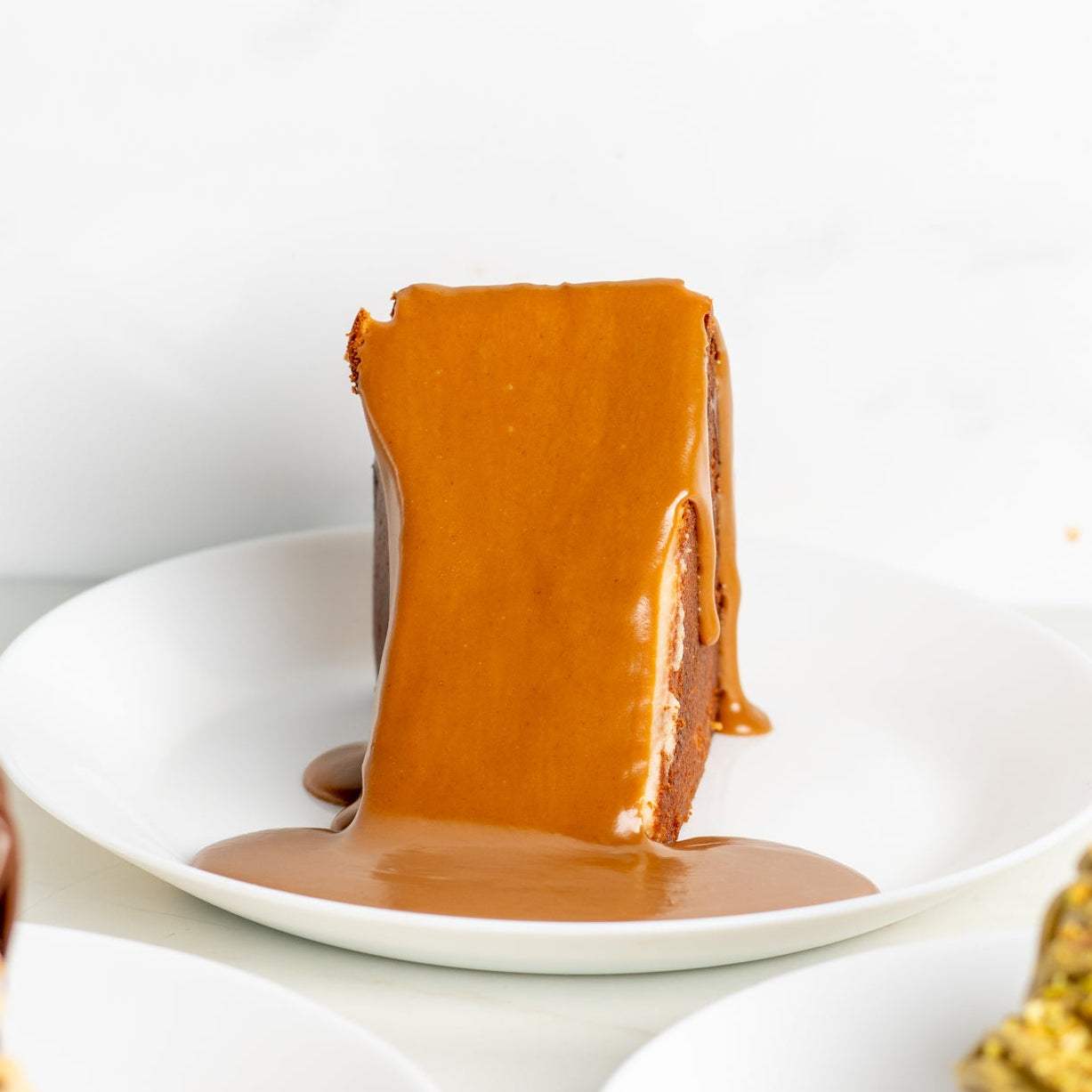Dessert with a caramel-like topping on a white plate against a white background